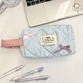 Dettaglio dell'astuccio trapuntato azzurro con fiocchi rosa e maniglia laterale - Quadri Blu Chiaro