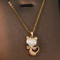 Golden cat pendant necklace with white opal and zircon stones on a leather texture background - Cat's Eye Persian Cat