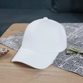 White solid baseball cap styled on a wooden table with lifestyle fashion accessories - White