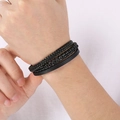 Dettaglio di bracciale multistrato in pelle intrecciata nera con chiusura in acciaio inox - Nero (KB204702-SJ)