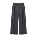 Detailed view of dark grey wide-leg trousers with white drawstring waist and draped fabric - XS / Blue