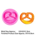 Pink silicone pretzel mold for DIY baking with orange pretzel replica and clear texture - B279 Pretzel / Pink
