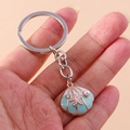 Primer plano detallado de un llavero de concha azul con una estrella de mar y perlas - Concha Azul