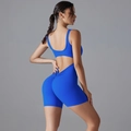 Detail view of the scrunch butt seam on a blue one-piece yoga romper with backless design - S / Klein Blue