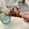 Detailed macro view of the amber tortoiseshell hair claw clip with a stylish bow design - 9.5CM / Khaki