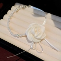Gros plan détaillé d'un collier de perles avec une grande fleur blanche en tissu - 珍珠玫瑰花项圈 / Blanc