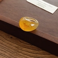 Gros plan détaillé d'une bague en résine ambre sur une boîte en bois vintage - Café Clair