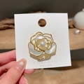 Elegant gold hollow camellia brooch featuring white shell petals and a centered pearl - White Camellia