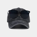 Detail of vintage washed cotton baseball cap featuring decorative goggles and metal rivets - Black