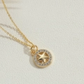 Detailed macro view of a gold star pendant with sparkling rhinestones on a curb chain - Pentagram