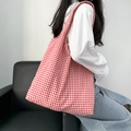 Detail of red and white checkered canvas tote bag worn by a model on shoulder - Red Plaid