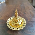 Close-up of golden hollow metal incense burner lid with vintage Middle Eastern patterns - Gourd Top
