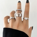 Set di anelli in argento con farfalla e cuore con zirconi sulla mano di una modella - Moda Farfalla Zircone Set Anelli Impilabili 4 Pezzi / Argento