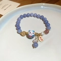 Dettaglio di bracciale con perline, ciondolo gatto in ceramica e pendente Youfu dorato - Gatto Portafortuna Blu Scuro (16 Perle)