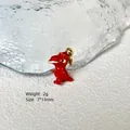 Macro shot of 7x13mm red enamel dinosaur charm for DIY jewelry making with gold ring - Red Dinosaur 8-39