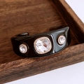 Macro-opname van zwarte hars manchetarmband met grote kristallen en goudkleurige rand - Zwarte Armband Met Heldere Steen