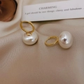 Eleganti orecchini a cerchio con perle dorate presentati su tessuto di seta beige morbido - Oro Bianco