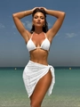 Close-up of white three-piece bikini set with textured fabric and matching sarong on beach - S / White