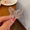Süße rosa transparente Schmetterling-Haarklammer in der Hand für Seitenfrisuren - Irisierendes Rosa