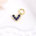 Golden heart-shaped pendant set with six deep blue zircons on a white textured background - Dark Blue