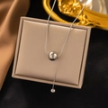 Macro shot of silver titanium steel necklace with double beads on display stand - Wish Fulfilled / Steel