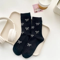 Black mid-calf knit socks with white bow patterns displayed on a beige tray - One Size / Black (HT39)