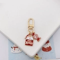 Detailed view of Santa Claus and candy cane charms on a festive golden metal keychain - Santa with Candy