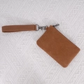 Brown washed canvas coin purse with wrist strap and metal hook on beige texture - Tan