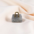 Miniature gray quartz handbag pendant with elegant gold handle on beige fabric - Labradorite