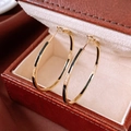 Detailaufnahme von 14k Gold-Creolen mit schwarzem Emaille und Zirkon-Inlay auf einer Lederbox - Gold (925 Sterling Silber Ohrringstift)