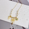 Dettaglio della collana San Benedetto in oro 18k con perle, cuore e ciondolo occhio - Stile 2