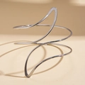 Detail of silver spiral arm cuff bracelet with sleek irregular curves and polished finish - Irregular Spiral Wave Arm Cuff / Silver