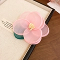 Detailed close-up of pink tulle flower hair clip with yellow pistils in a wooden jewelry box - Pink Flower Duckbill Clip