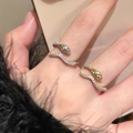 Elegante goldene und silberne Schlangenringe mit funkelnden Steinen am Finger - Gold Doppelschlange Set (J970)