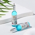 Set of two miniature blue resin wine bottle pendants with silver keychains on a white stone - Blue