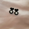 Detail of acrylic heart earrings with clear silicone backings on pink silk background - Black