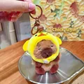 Cute Capybara plush keychain wearing yellow duck hat with small bell charm detail - Chicken Headwear 2.0