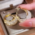 Detailed close-up of gold hoop earrings with zircon pavé worn by a model - Full Pave Crescent Wide Hoop (E1825 Gold) / 925 Silver Needle / Gold