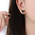 Golden heart stud earrings with black enamel center shown on ear and held in hand - Gold Black Acrylic Heart Stud Earrings (F955) / 1.0x1.1cm