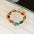 Vue détaillée du bracelet doré avec pierres précieuses ovales colorées sur un coussin - 81# Bracelet - Style Pierre Gemme Couleur Ovale Résine