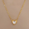 Detail of a gold heart pendant necklace featuring a central white zircon on champagne background - Gold