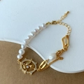 Detalle de pulsera de perlas de agua dulce con cadena de eslabones dorada y dije de flor - Pulsera de Perlas de Agua Dulce Rosa