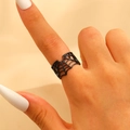 Détail d'une bague araignée ajourée noire portée au doigt au style gothique - Blanc K (M-720)