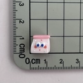 Close-up of mini pink resin cartoon charm next to a ruler showing its 1cm small size - 01*Pink Milk Bottle Mini