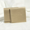 Two luxury golden PU leather jewelry pouches with drawstrings on white silk background - Gold