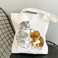 White canvas tote bag featuring cute cat and dog illustrations on a black chair - Cat and Dog
