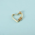 Detailed view of heart-shaped gold pendant with screw clasp on blue background - Gold Heart Pendant