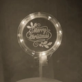 Detail view of acrylic Merry Christmas cake topper with warm LED light and holly engraving - Style 4 Warm Light