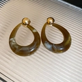 Detail of brown marble resin teardrop earrings with gold ball studs on textured glass - Green