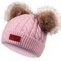 Détail du bonnet en tricot torsadé rose avec deux pompons marron et étiquette en cuir - Rose Clair